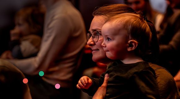 Eine Frau hält ein Baby auf ihrem Schoss